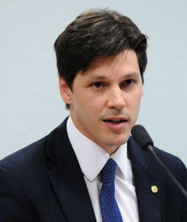 Ein Mann im Anzug spricht in ein Mikrofon an einem Rednerpult, wahrscheinlich zur Genehmigung eines Gesetzes durch die Regierung.