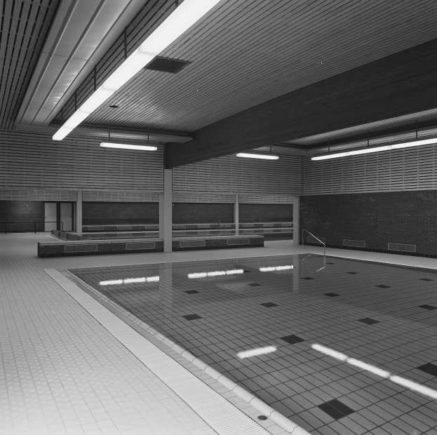 Innenpool mit kristallklarem Wasser, umgeben von gefliesten Wänden und Boden, Deckenbeleuchtung und einigen umliegenden Gegenständen in einer friedlichen Umgebung.