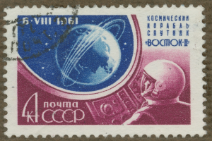 Eine Briefmarke mit einem Mann im Weltraumanzug mit entschlossener Miene, umgeben von der fettgedruckten, weißen Schrift "Marke"