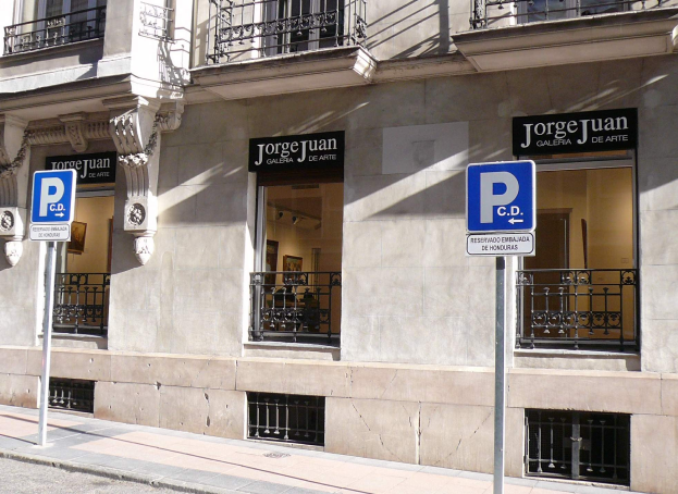 Ein mehrstöckiges Gebäude mit Fenstern, Geländern, Türen und Säulen, das Werbetafeln auf Pfosten entlang des Gehwegs und sichtbare Innenobjekte zeigt, die eine belebte städtische Umgebung suggerieren.