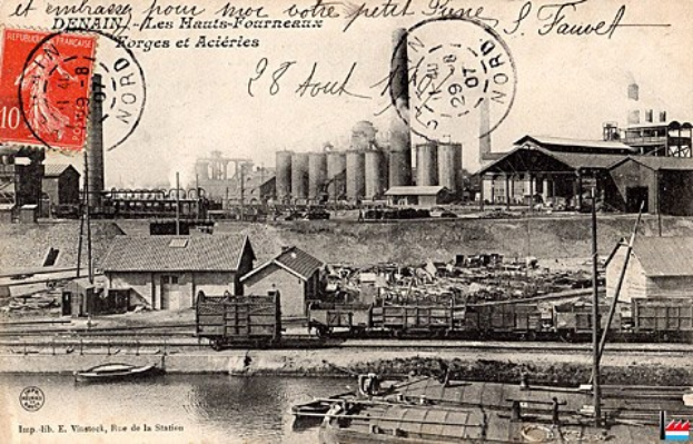 Alte Postkarte mit einer Fabrik im Hintergrund, Häusern, Strommasten, Schiffen und Wasser, mit Stempeln und handgeschriebener Text.
