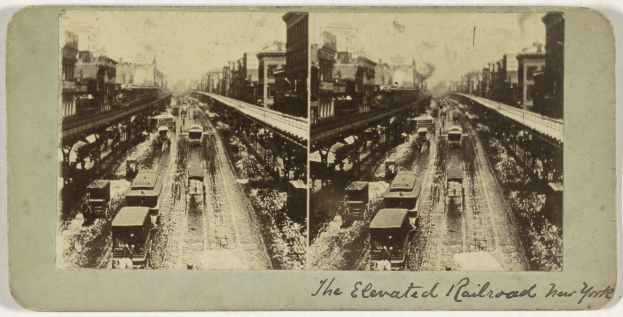 Schwarzes und weißes Foto eines Zuges auf einer erhöhten Eisenbahnstrecke in New York City mit mehreren Fahrzeugen auf der Strecke, Menschen und Gebäuden im Hintergrund sowie Text unten.