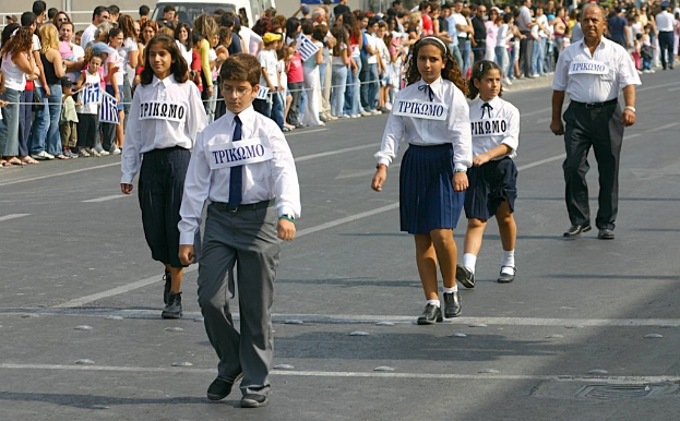 Menschen auf einer Straße bei einem Ereignis, tragen Abzeichen und sind von einer großen Menge umgeben.