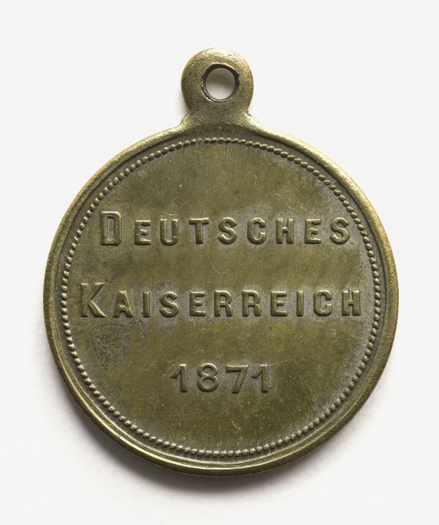 Eine Bronzemedaille mit der Aufschrift "Deutsches Kaiserreich 1871" auf einem weißen Hintergrund.
