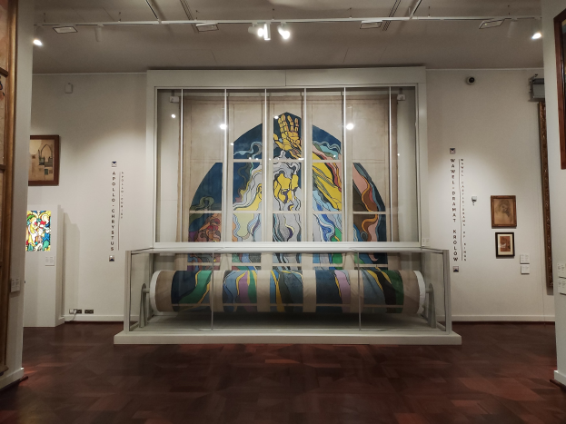 Ein Ausstellungsraum im Museum of Modern Art in New York, der zahlreiche Gemälde zeigt, darunter eines in einer Glasvitrine, gerahmte Kunstwerke an den Wänden und Deckenbeleuchtung.