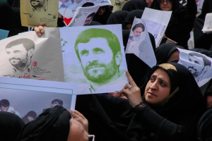 Eine Gruppe iranischer Frauen in schwarzer Kleidung, einige tragen Brillen, halten Fotos des Präsidenten Mahmoud Ahmadinejad während einer Demonstration in Tehran hoch.