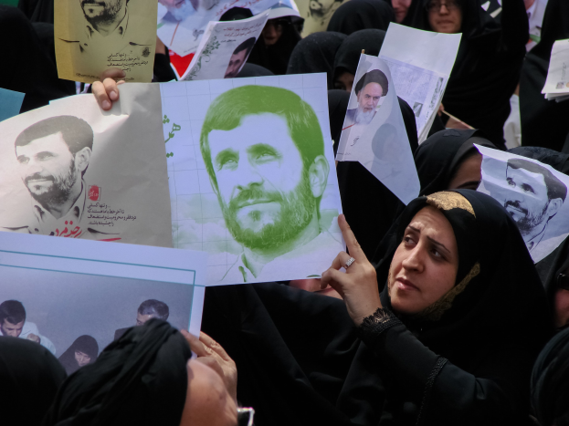Eine Gruppe iranischer Frauen in schwarzer Kleidung, einige tragen Brillen, halten Fotos des Präsidenten Mahmoud Ahmadinejad während einer Demonstration in Tehran hoch.