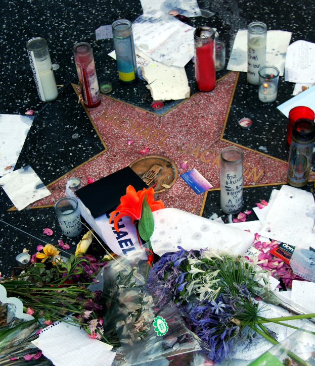 Star auf dem Hollywood Walk of Fame umgeben von Blumenbouquets, Kerzen, Papieren und anderen Gedenkgegenständen.