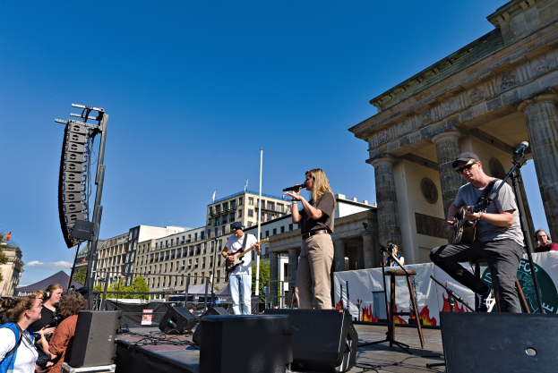 Eine Gruppe von Menschen, die auf einer Bühne vor dem Brandenburger Tor in Berlin Musik spielen
